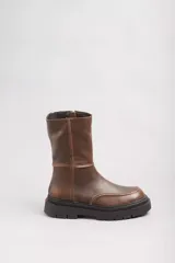 Bota de cuero marrón con caña media, puntera redondeada y suela track de goma negra.