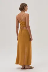 Falda midi color mostaza, tejida con textura y corte en el frente.