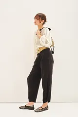 Pantalón sastrero negro con ajuste en el tobillo, tiro alto, bolsillos delanteros y traseros, pinzas en el frente, confeccionado en cupro y viscosa.