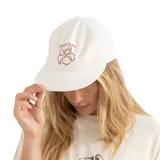 Gorra de visera color crema con bordado frontal de una flor y la palabra Rhythm en color marrón.
