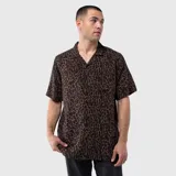 Camisa de manga corta con cuello cubano, confeccionada en viscosa con estampado animal print. Presenta un bolsillo frontal en el pecho y cierre de botones.
