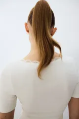 Top en punto acanalado fino de algodón, de color blanco, corte entallado, mangas cortas y escote en V pronunciado ribeteado con encaje.