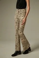 Pantalon de jean con corte flare y tiro alto, estampado con diseño animal print de leopardo en tonos marrones. Cuenta con bolsillos funcionales y ruedo desflecado.