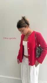 Cárdigan rojo de algodón con botones blancos, cuello redondo y mangas largas.