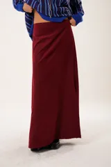 Falda larga color borgoña, confeccionada en tela suave con acabado tipo piel de durazno y cierre invisible lateral.