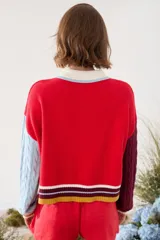 Cardigan de punto con diseño tricolor, de corte relajado, manga larga de tejido trenzado en contraste de color, cuello solapa tipo polo y cierre frontal de botones.