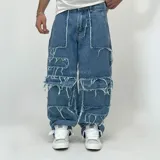 Pantalón de jean azul con corte ultra baggy, diseño patchwork con piezas de denim con bordes deshilachados.