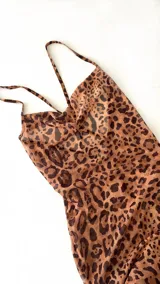 Vestido largo ajustado de microtul elastizado, con estampado de leopardo en tonos marrón y negro. Presenta escote drapeado tipo cowl neck y tirantes finos ajustables.