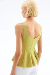 Top sin mangas de punto interlock pesado, con escote en V tanto en el frente como en la espalda. Presenta un diseño entallado con pliegues cosidos que se abren en la parte inferior creando un efecto peplum con vuelo.