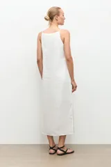 Vestido midi de lino color blanco, de corte recto y holgado, con escote cuadrado y tirantes finos.