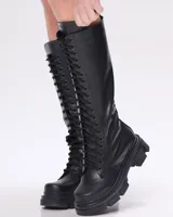 Bota larga acordonada de cuero vacuno color negro, con suela track y chapita con logo de la marca.