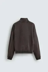 Sudadera de corte boxy fit con cuello subido y cierre frontal de cremallera. Presenta mangas largas, acabado efecto lavado y puños y ruedo en rib.