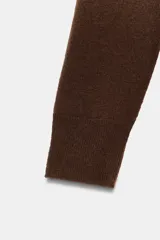 Jersey de manga larga confeccionado en hilatura de lana 100%, con escote en pico y acabado de punto fino.