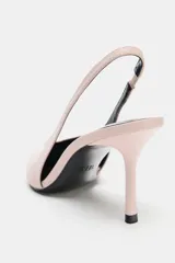 Zapato de tacón destalonado color rosado, con diseño de punta fina, escote en V y tira trasera elástica. Cuenta con tacón alto y fino.