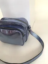 Bandolera rectangular de cuero azul metalizado con correa larga regulable. Cuenta con un bolsillo frontal con fuelle y un bolsillo trasero con cierre.