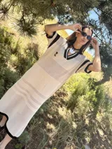 Remerón tejido de punto color azul marino con calados, cuello estilo camisa en verde oscuro con rayas blancas y verdes, y logo bordado en blanco en el pecho.