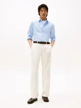 Camisa celeste de corte slim fit, confeccionada en tejido dobby de algodón con tecnología Flex. Presenta cuello abotonado, manga larga y logo de Tommy Hilfiger bordado en el pecho.