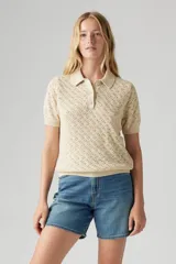 Remera color crema de tejido de punto calado, con cuello polo y mangas cortas.