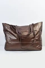 Bolso tipo shopper de diseño acolchado con acabado brillante, color marrón visón. Cuenta con doble asa de hombro y correa larga ajustable y extraíble.