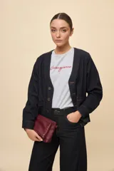 Sobrecamisa de jean azul oscuro, de calce relajado, escote en V, bolsillos delanteros aplicados, cierre frontal con botones metálicos y pespuntes en contraste.