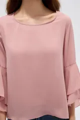 Blusa negra de poliéster, con cuello redondo, mangas 3/4 con volados en capas y diseño holgado.