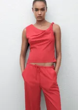 Pantalón de corte recto y tiro medio, confeccionado en tejido fluido. Cuenta con cintura elástica con cordón ajustable, bolsillos laterales y diseño largo.