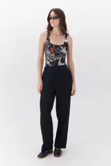 Malla enteriza negra con estampado de hojas de palmeras, flores y aves exóticas.