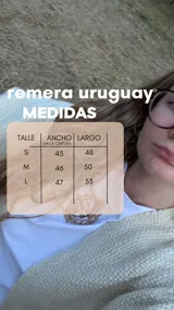 Remera blanca de algodón con cuello bote y detalle de elástico en los hombros. Presenta un estampado central de un sol en color dorado.