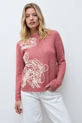 Sweater de punto color rojo melange, con cuello redondo, manga larga y detalle de bordado floral en relieve en color crudo en el frente.