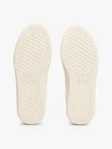 Zapatillas blancas de cuero con cordones, suela cupsole color crema y talón celeste.