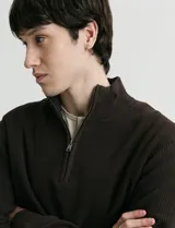 Cardigan de punto color azul marino, con cuello alto y cierre frontal parcial. Presenta diseño de punto inglés en cuerpo y mangas, con terminaciones en punto canalé en cuello y puños.
