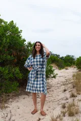 Túnica de corte amplio con estampado de cuadros azules y blancos, cuello redondo y mangas 3/4. Incluye cinturón de la misma tela.