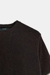 Jersey de punto de cuello redondo y manga corta con acabado en rib.