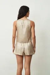 Blusa plateada sin mangas con textura brillante.