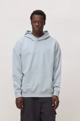 Hoodie de corte holgado en color celeste, con capucha, bolsillo frontal tipo canguro y detalle de logo bordado en el centro del pecho.