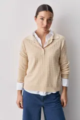 Sweater de punto color verde militar, con cuello polo y cierre frontal de botones, de manga larga con puños elastizados y diseño texturizado con relieve geométrico.