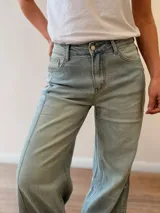 Pantalón jeans tipo palazzo de corte amplio y tiro medio-alto, con lavado celeste vintage y dobladillo vuelto con detalle de rayas en la terminación. Cuenta con bolsillos delanteros y traseros.