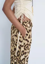 Pantalon de tiro medio con diseño recto y fluido, confeccionado en viscosa con estampado animal print de leopardo. Cuenta con cintura elástica con lazo de ajuste, forro interior y bolsillos laterales.