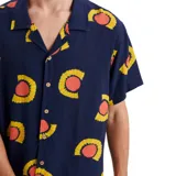 Camisa de manga corta azul con estampado de soles amarillos y naranjas.