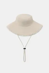 Gorro tipo bucket de algodón color beige, con ala ancha con acabado deshilachado y pespuntes, y cordón ajustable con stopper.