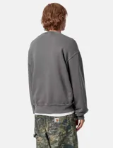 Buzo de algodón color azul con cuello redondo, puños y cintura acanalados. Tiene un corte holgado y un pequeño logo cuadrado bordado en el pecho.