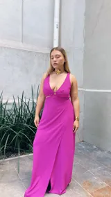 Vestido largo de crepé con acabado metalizado, escote en V profundo con detalle de aro central, aberturas laterales en la cintura y falda con tajo frontal.