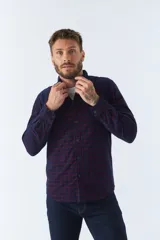 Camisa de manga larga confeccionada en pana de algodón con estampado de cuadros en tonos azul y bordó. Presenta cuello clásico, cierre frontal con botones y ajuste regular.