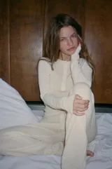 Pantalón negro de tejido de punto, tiro alto, con cintura elástica y detalle de tres botones frontales. Corte de pierna recta y ancho.