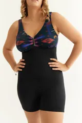 Malla entera short combinada, con estampado abstracto en tonos azul, rojo y negro en la parte superior y short negro liso. Presenta aplique metálico en el escote y bolsillo interno para colocar copa removible o prótesis externa. Confeccionada con tela que contiene fibra LYCRA® XTRA LIFE™.