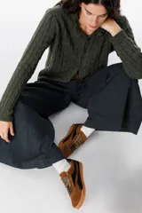 Zapatillas urbanas de cuero con diseño bicolor en tonos camel y negro, con cordones jaspeados y suela de goma color caramelo.