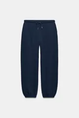 Pantalón jogger de tiro alto y color azul marino, con cintura elástica ajustable mediante cordones con herretes metálicos y puños elásticos en los tobillos.