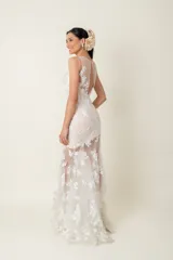 Vestido largo de tul blanco con apliques florales bordados, corte sirena y cuerpo con viso color natural.