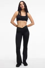 Calza deportiva de corte oxford, color negro, con cintura cruzada en V que brinda soporte y ajuste al cuerpo.