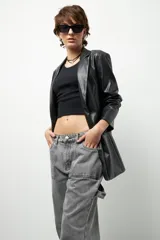 Jean de corte carpenter, estilo wide leg y tiro bajo, en color gris lavado. Presenta diseño de bolsillos frontales tipo parche y costuras reforzadas.